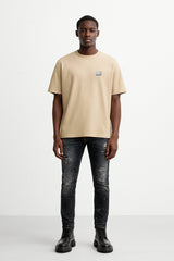 CAMISETA BEIGE CON PLACA CON LOGOTIPO
